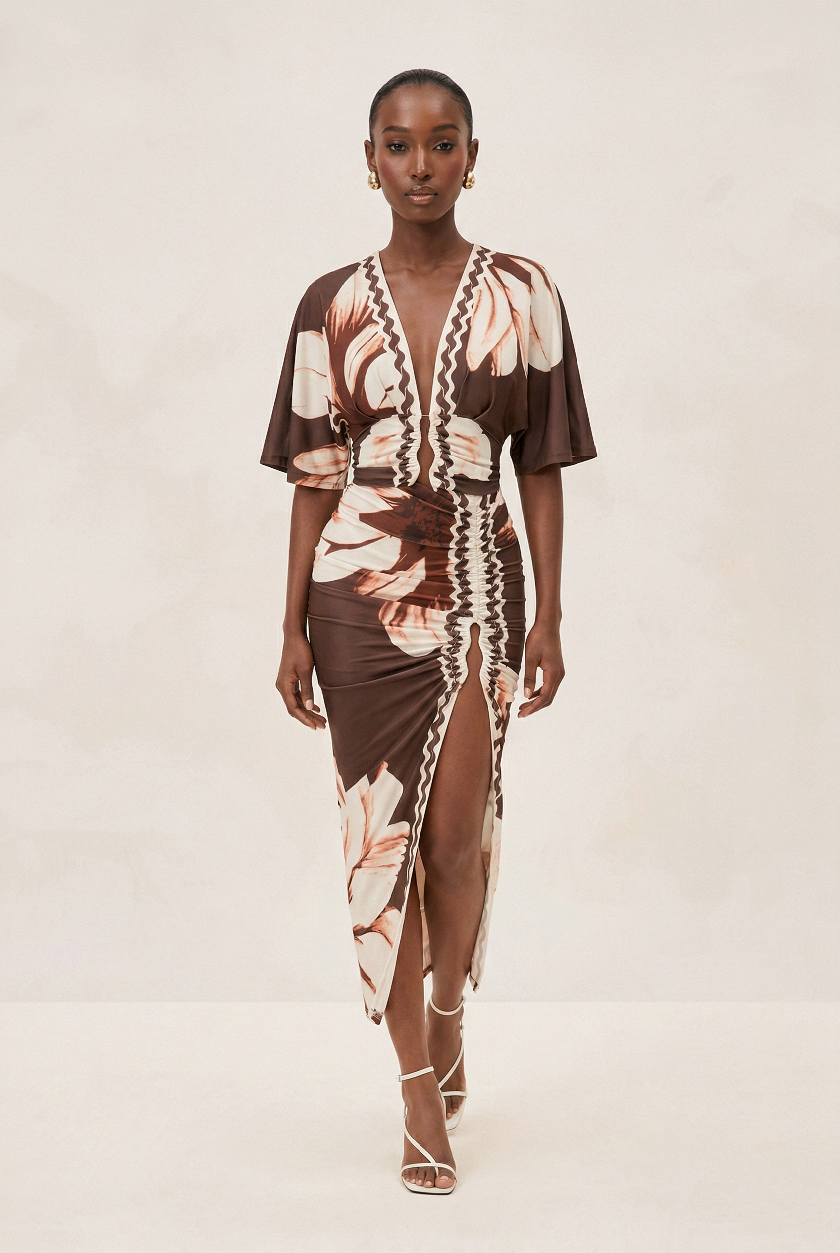 Woman wearing a brown and beige patterned dress on a white background