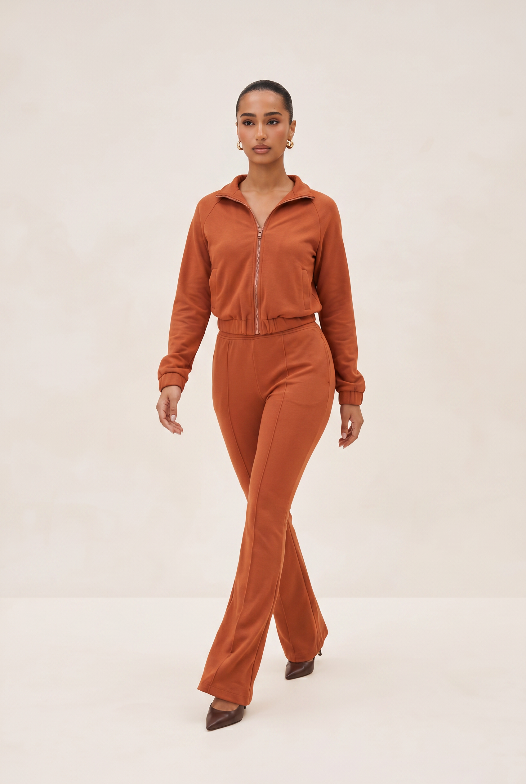 Woman wearing a brown tracksuit on a white background