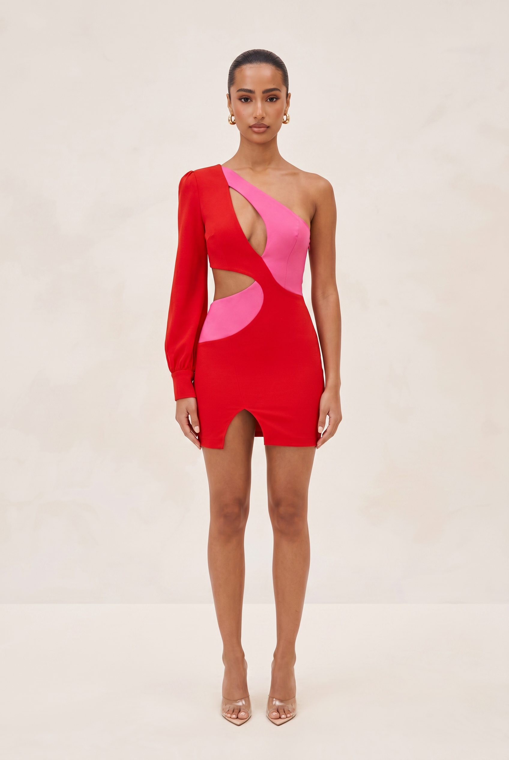 Woman wearing a red and pink dress with cut-out design on a beige background