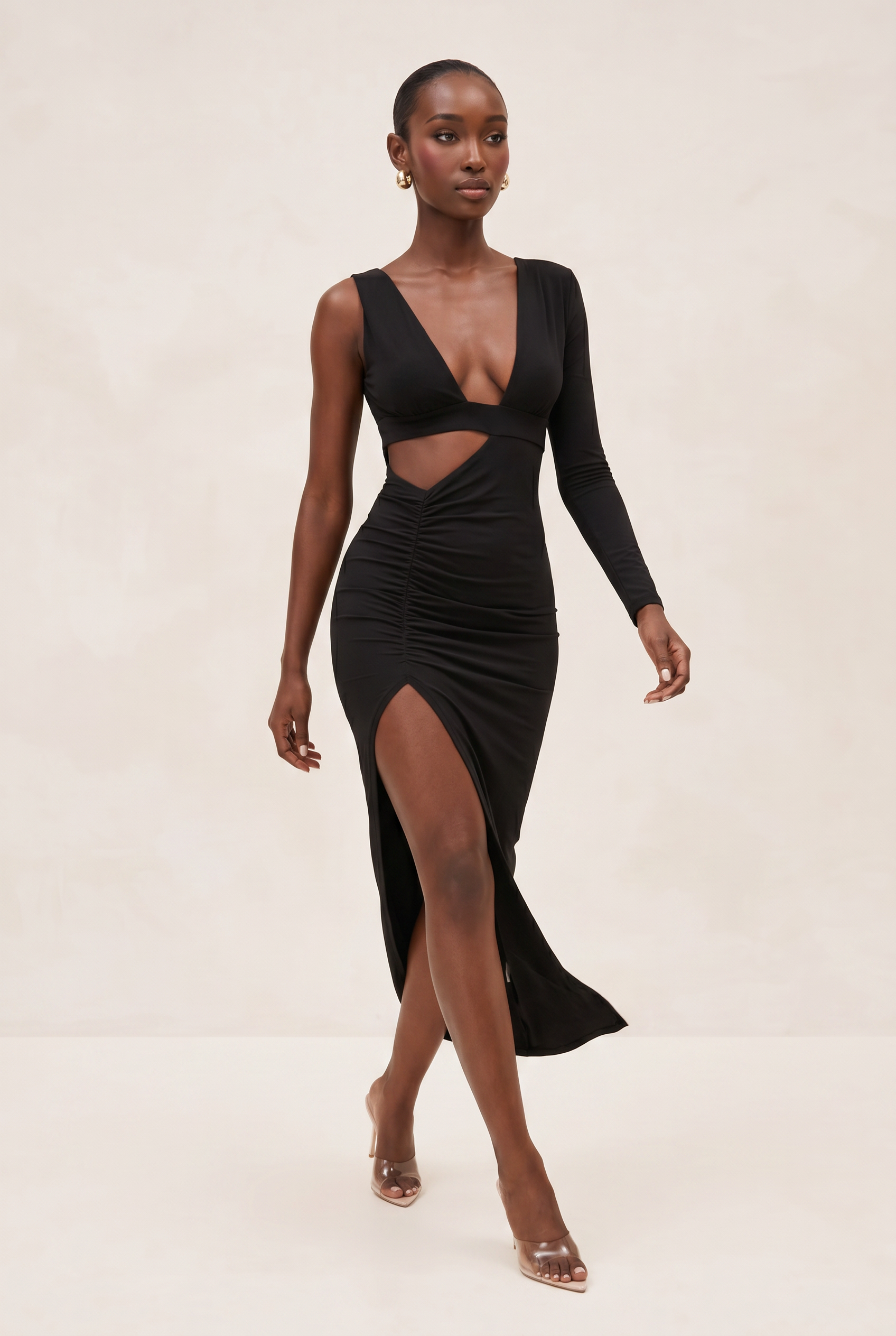 Woman wearing a black dress with cut-out design on a beige background
