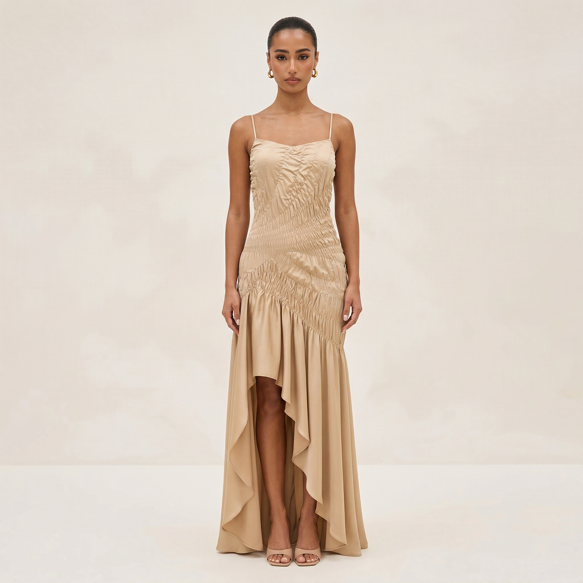 Woman wearing a beige evening gown on a plain background