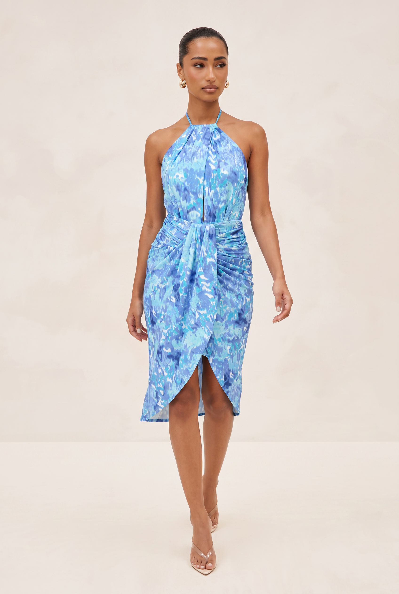 Woman wearing a blue floral dress on a beige background
