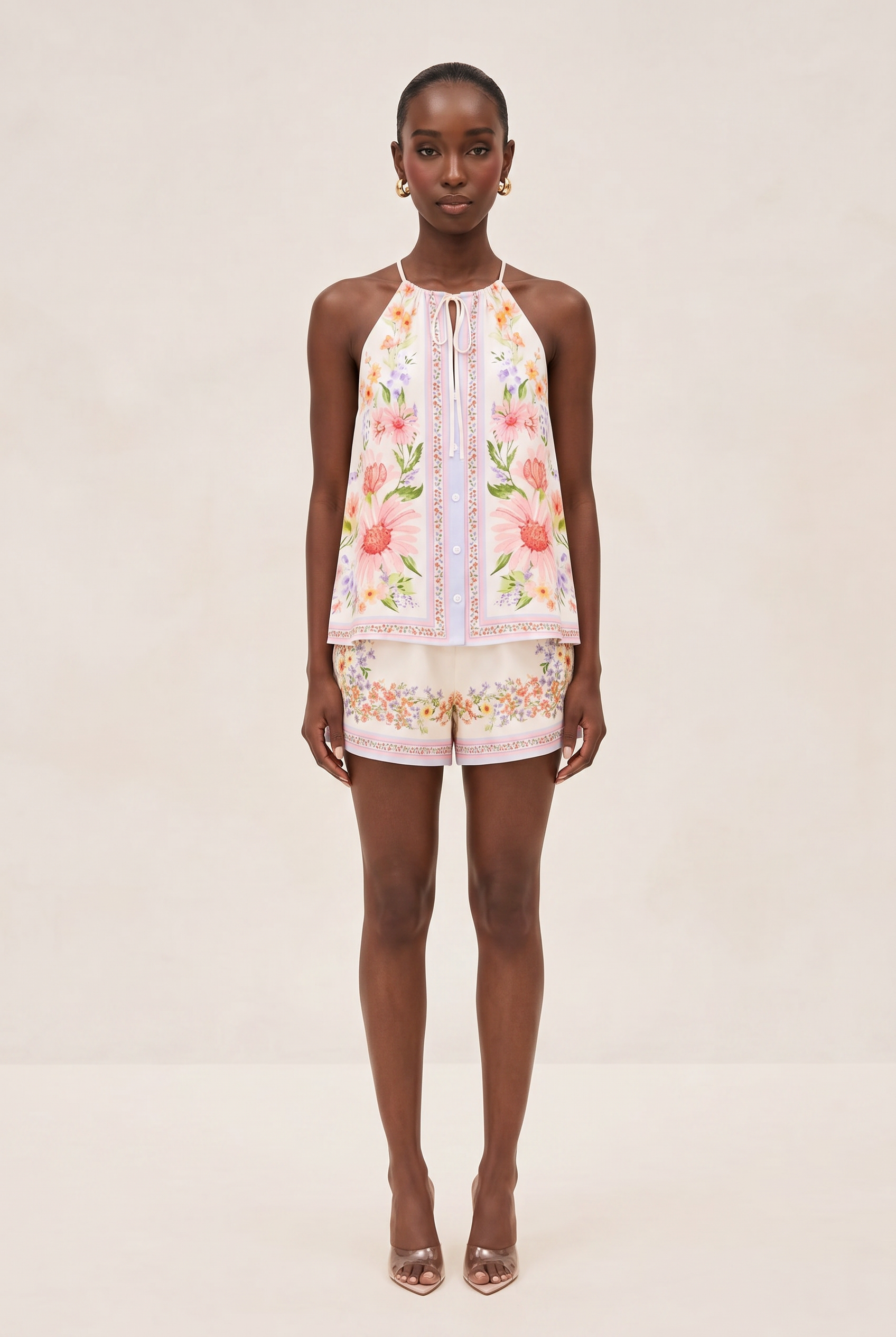 Woman wearing a floral top and shorts on a beige background