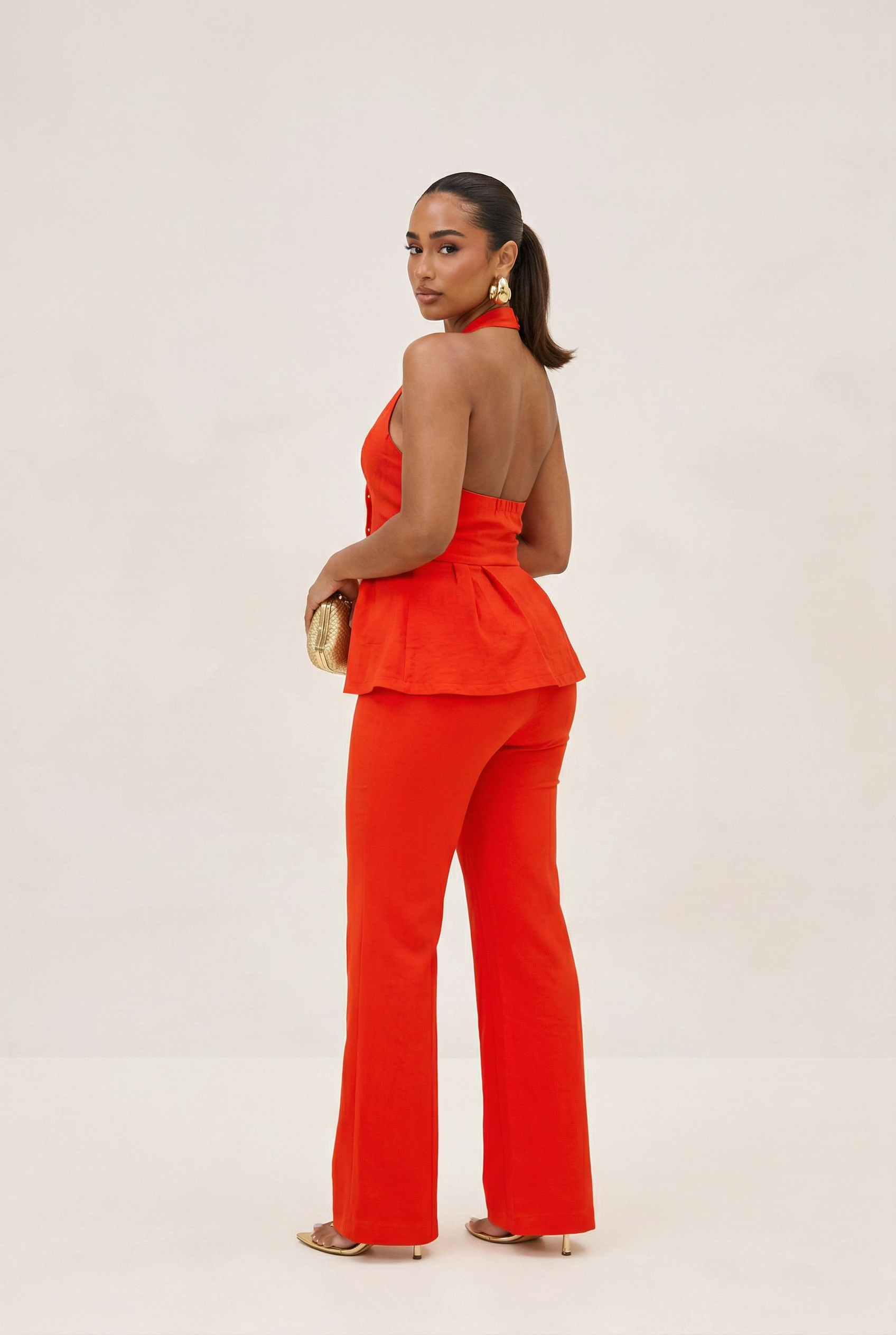 Woman wearing a bright red outfit on a plain background