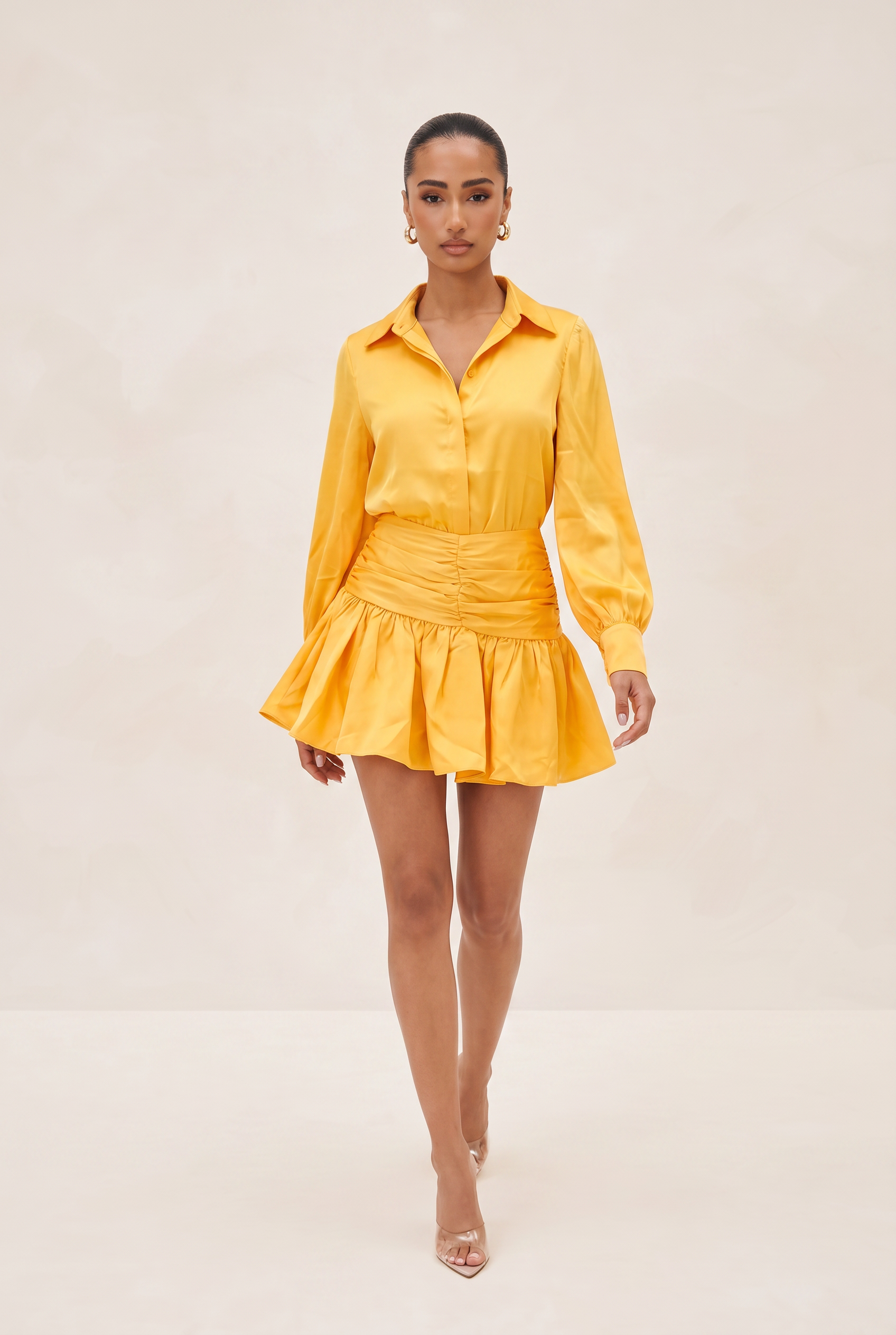 Woman wearing a yellow outfit on a beige background