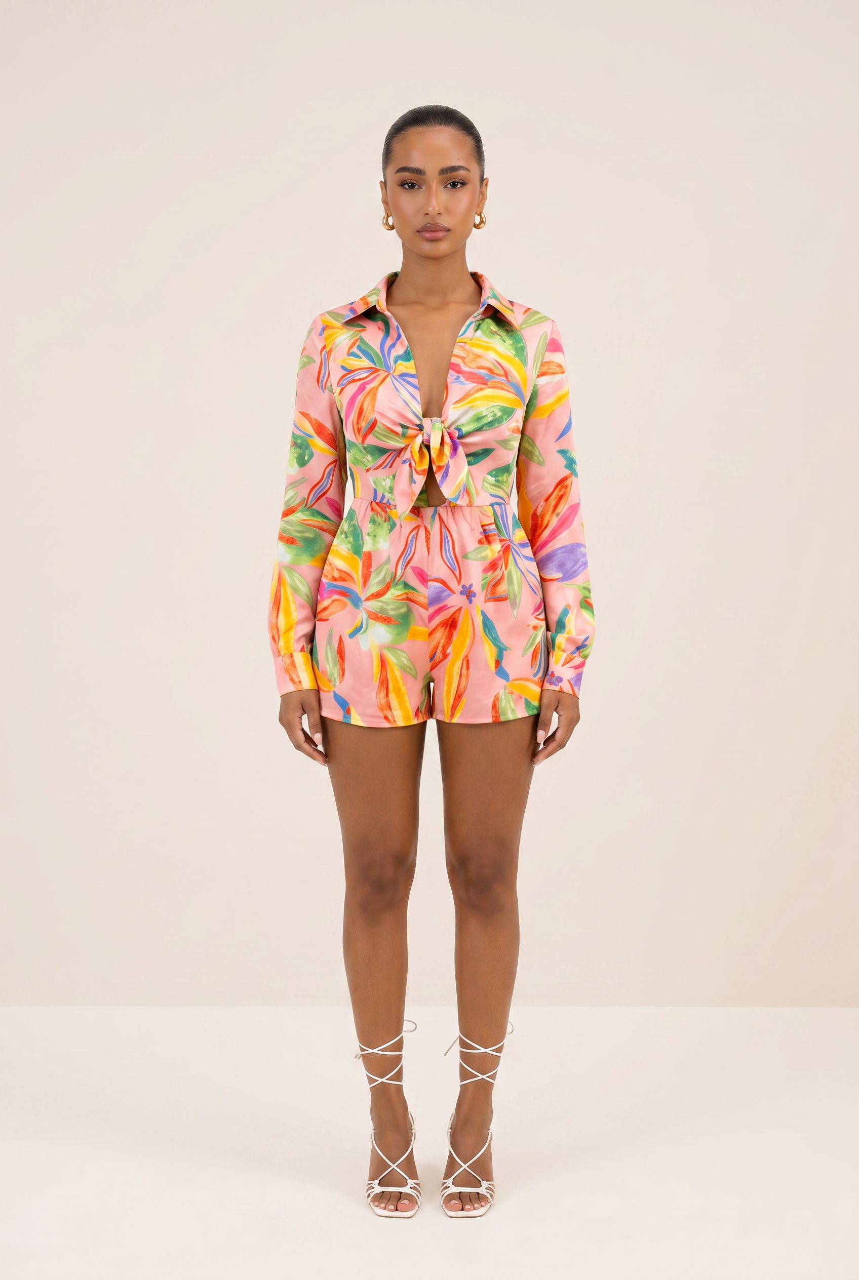 Model wearing a colorful tie-dye outfit on a beige background
