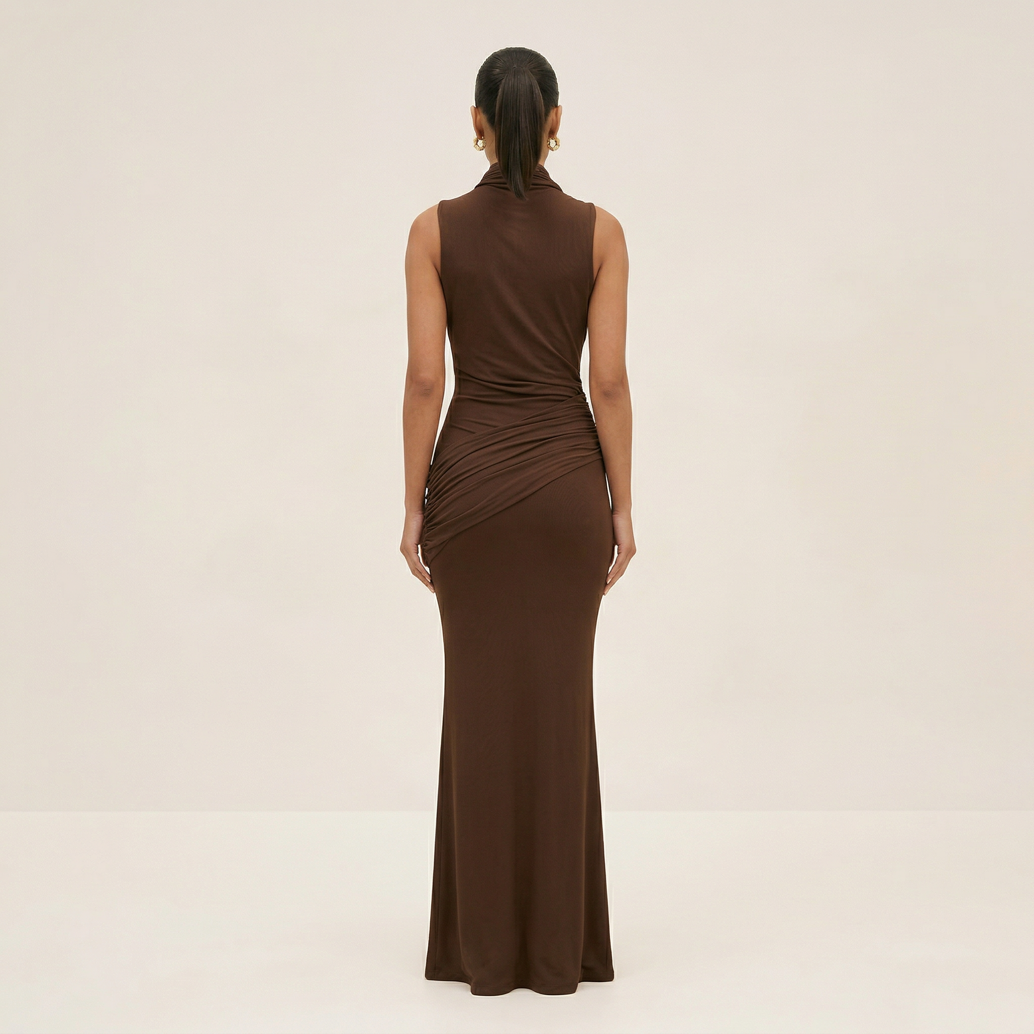 Woman wearing a brown sleeveless dress on a beige background