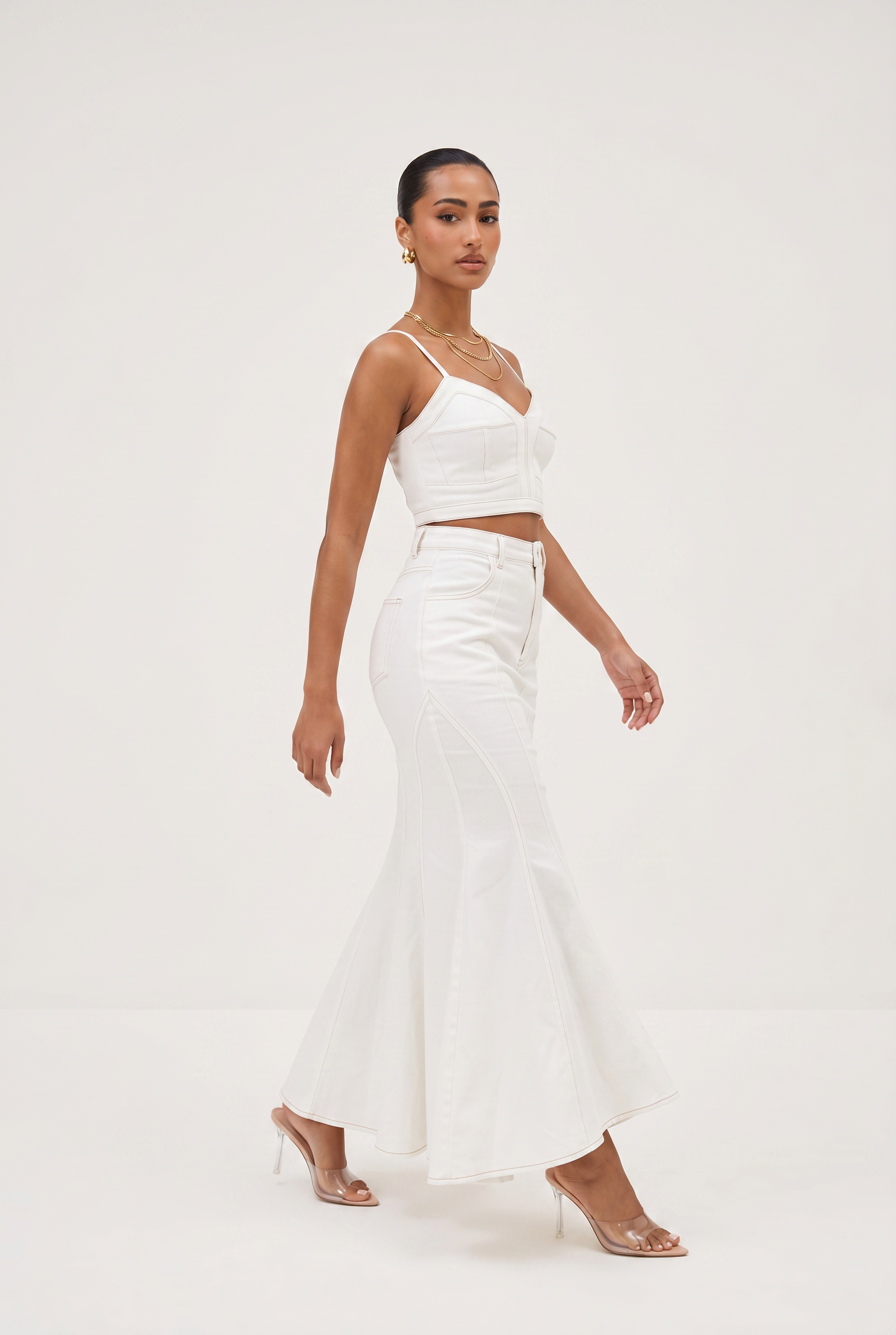 Woman wearing a white outfit on a plain background