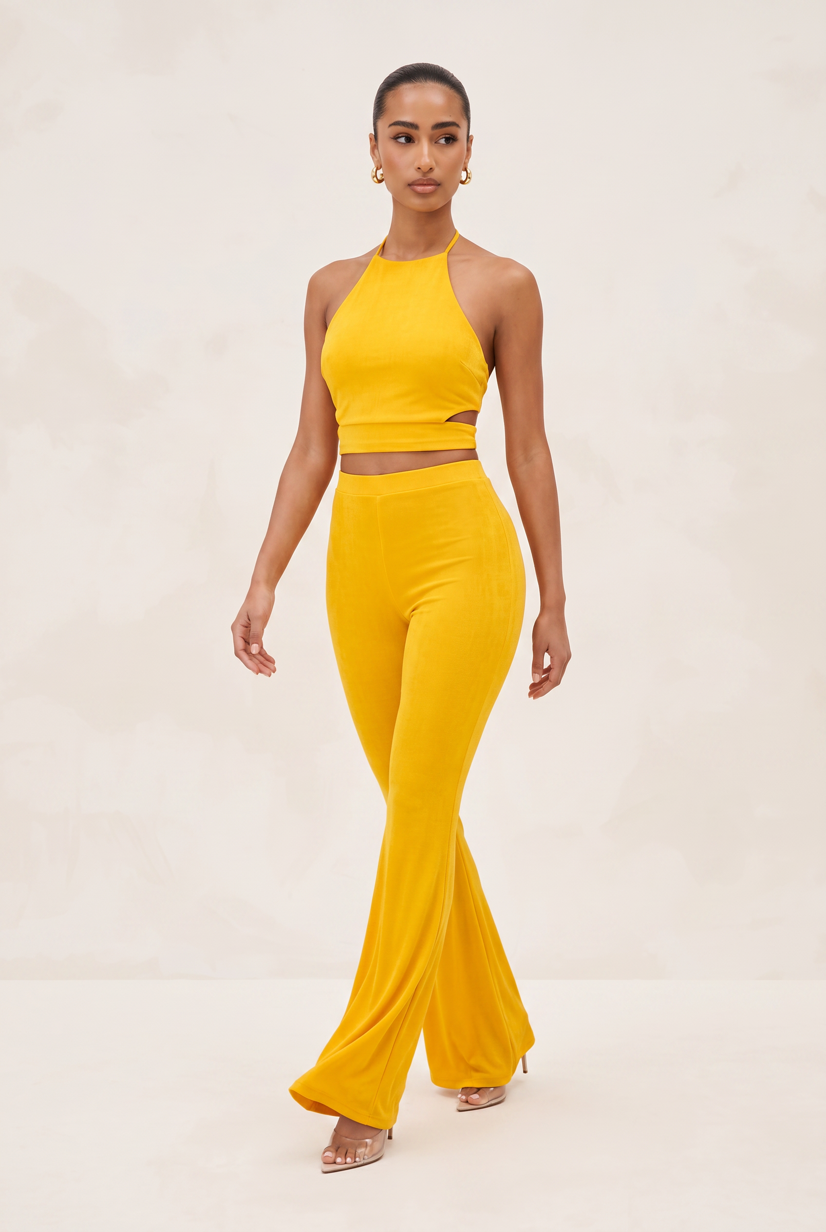 Woman wearing a yellow outfit on a beige background