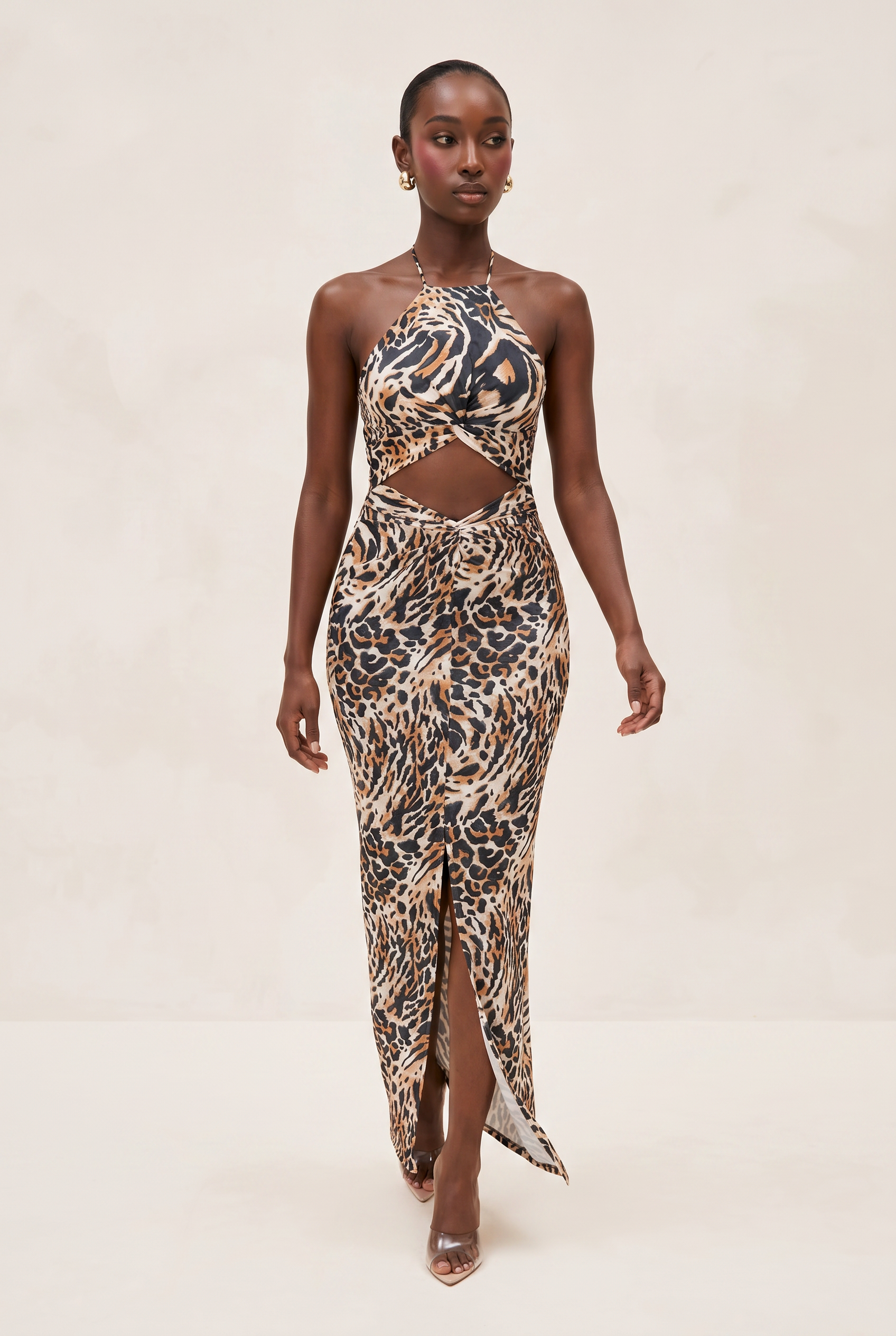 Woman wearing a leopard print dress with cut-out design on a beige background
