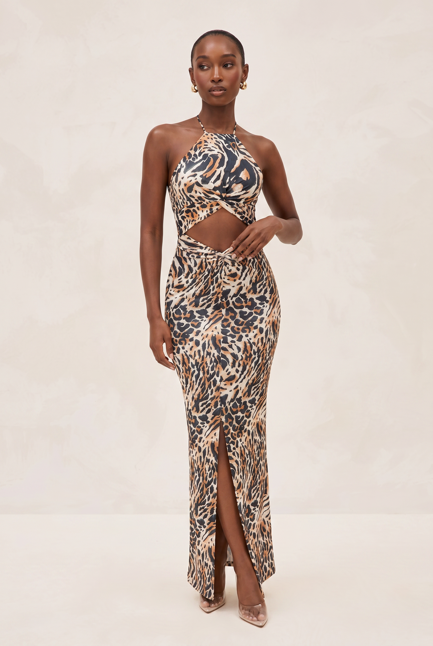 Woman wearing a leopard print halter neck dress on a white background