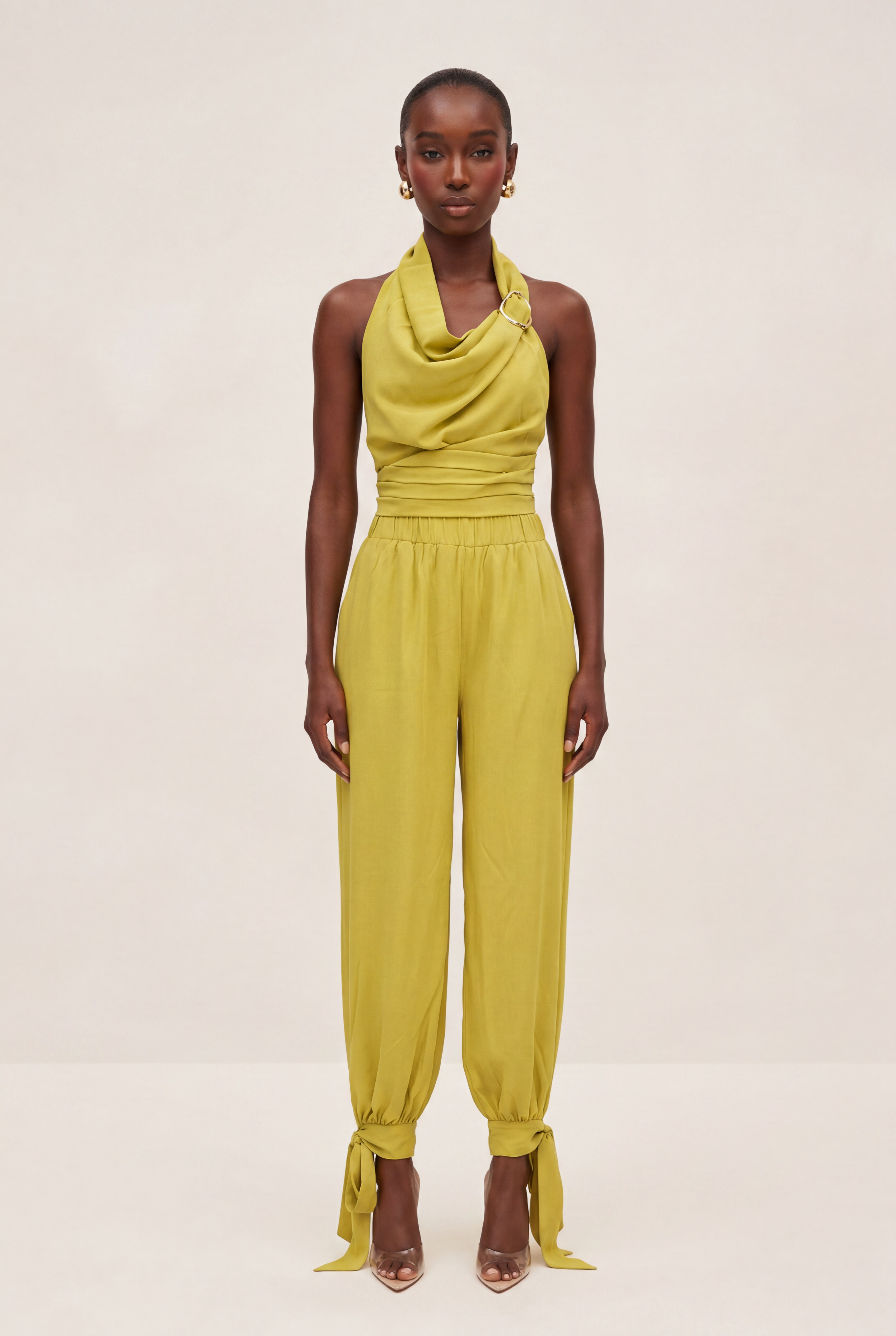 Woman wearing a yellow jumpsuit on a plain background