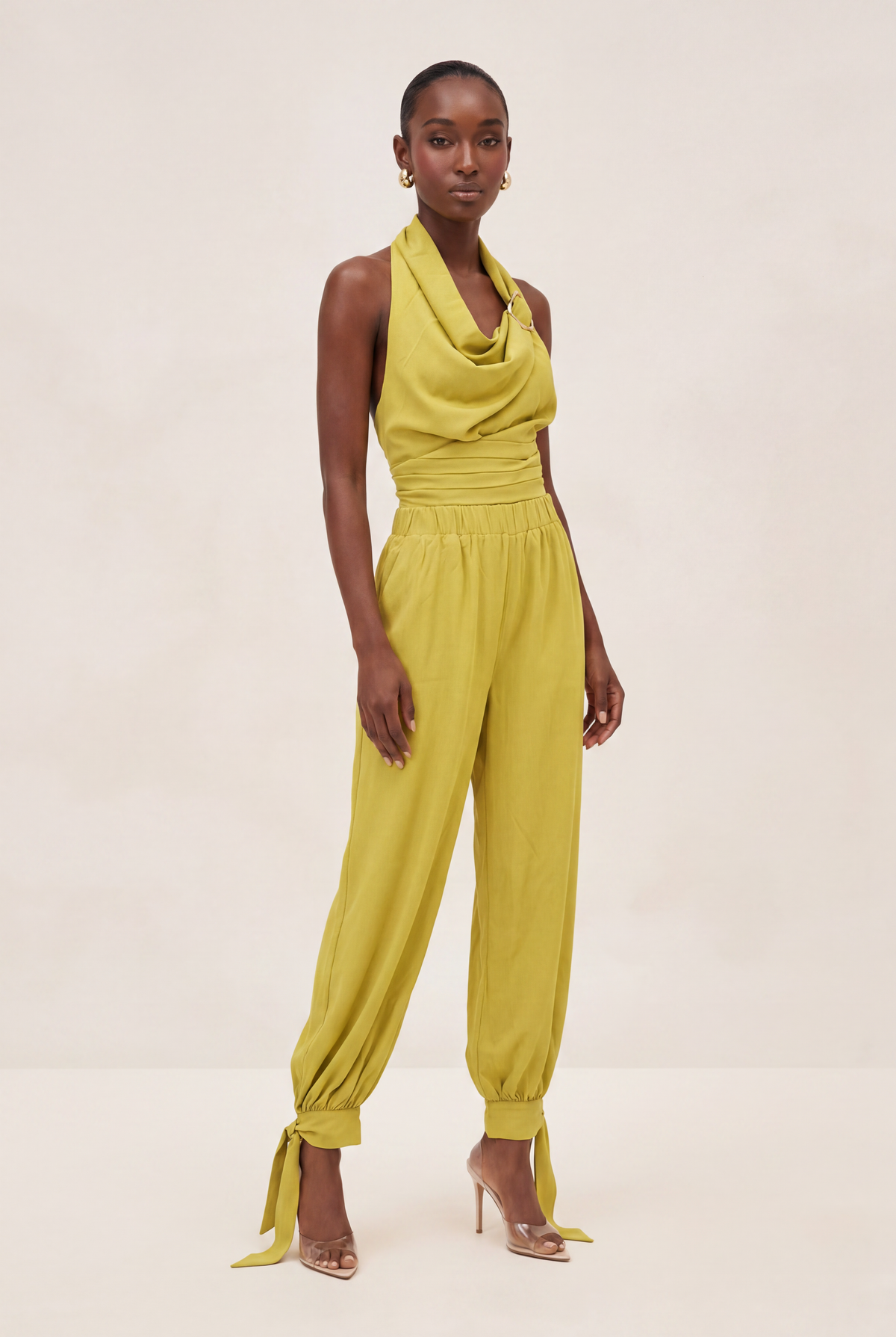Woman wearing a yellow jumpsuit on a beige background