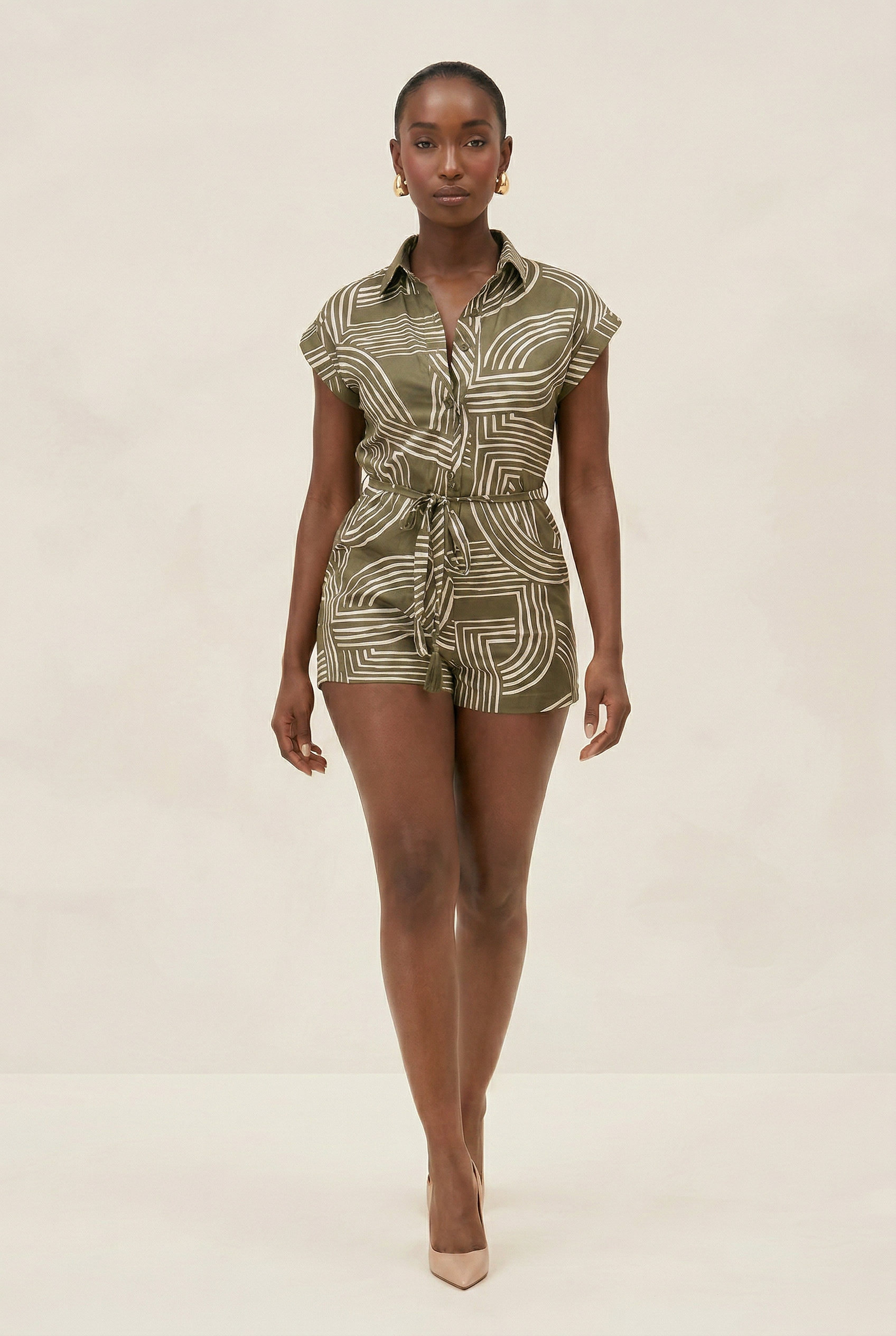 Woman wearing a patterned romper on a beige background