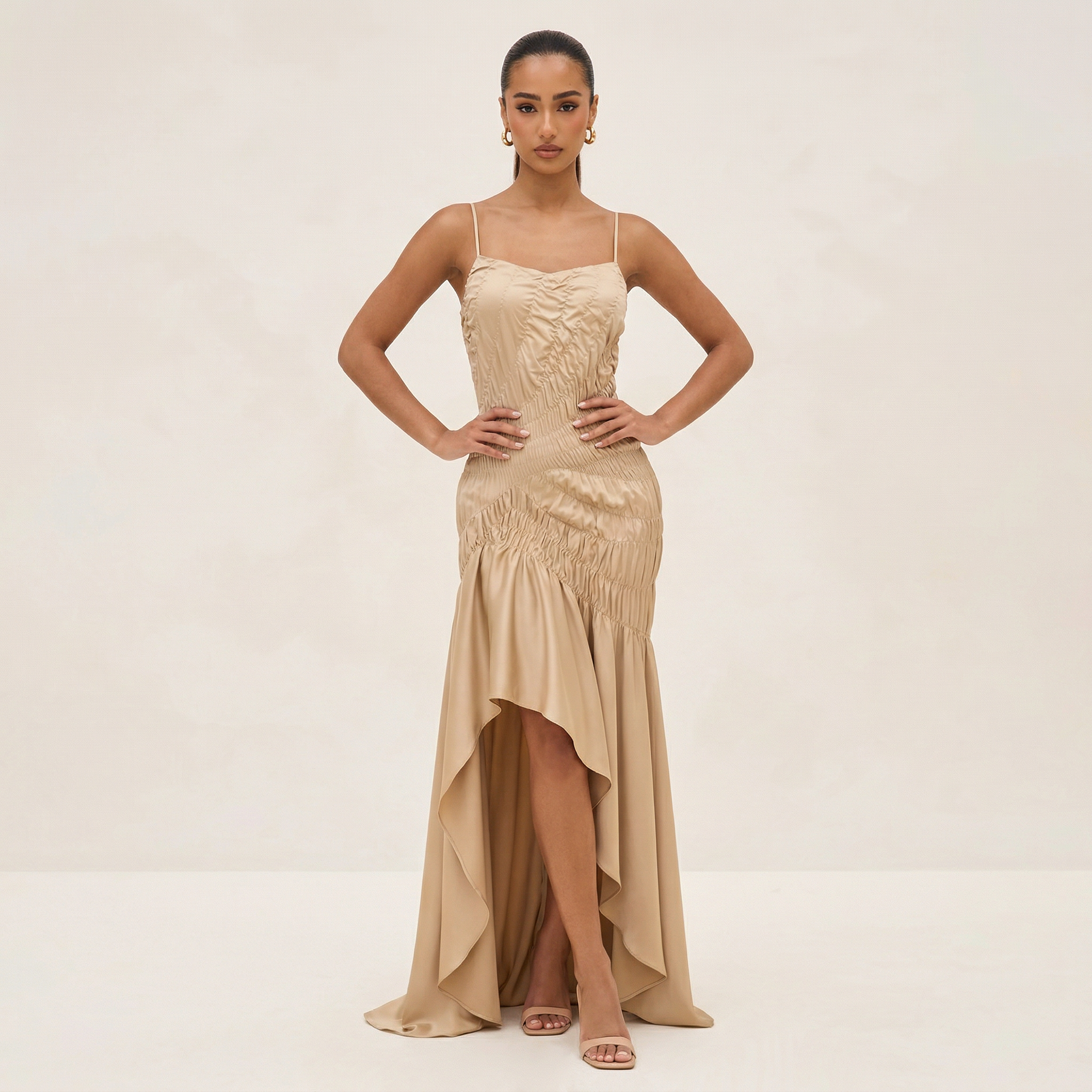 Woman wearing a beige evening gown on a plain background