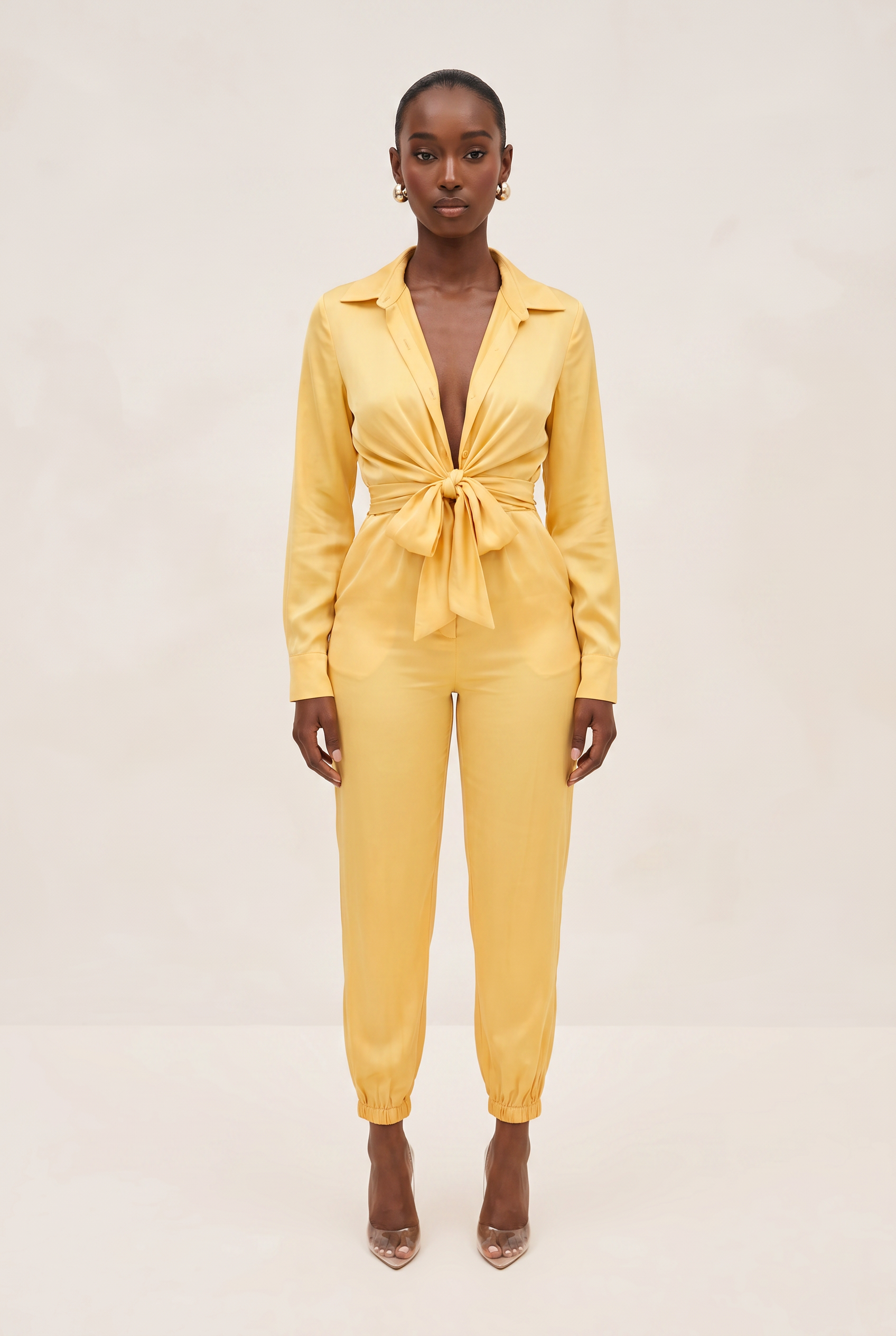 Woman wearing a yellow jumpsuit on a beige background