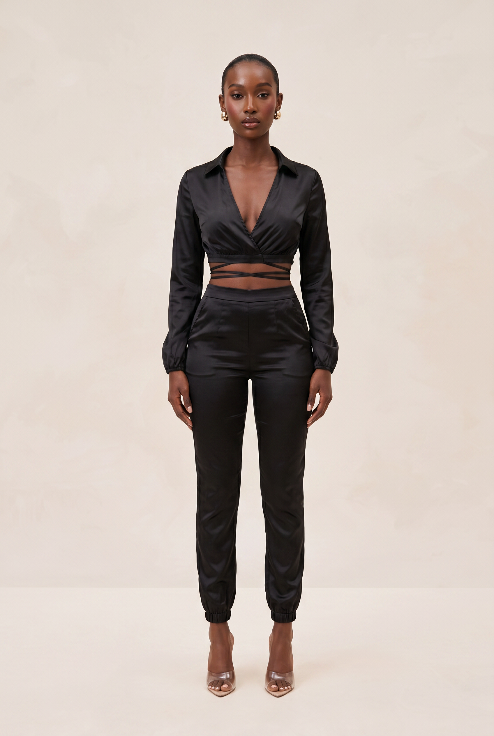 Woman wearing a black outfit with a beige background