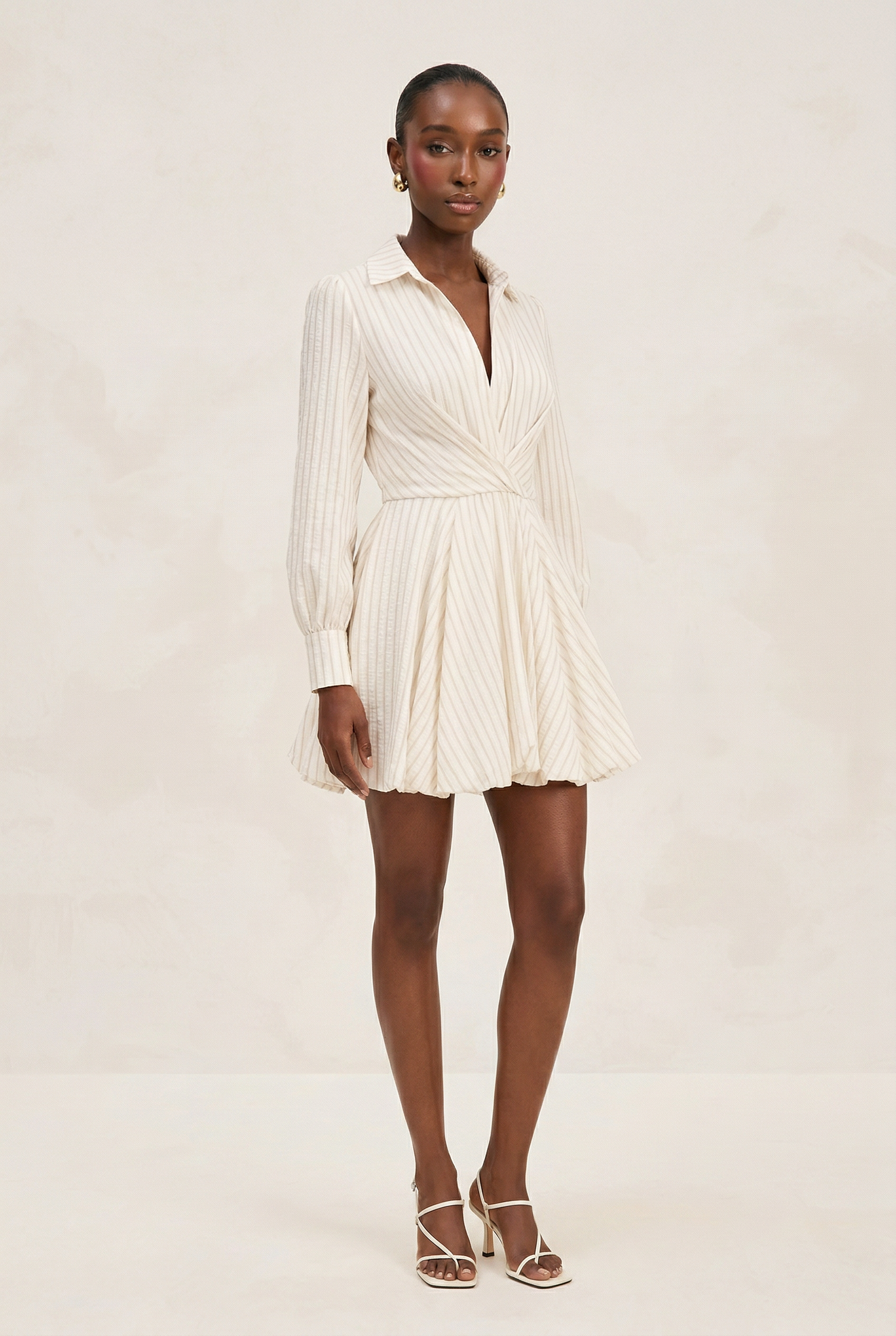 Woman wearing a white dress on a plain background