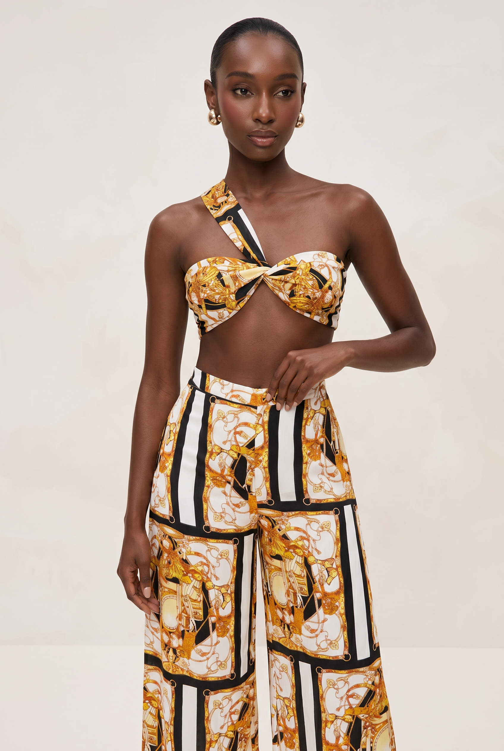 Model wearing a patterned outfit with a top and pants on a plain background