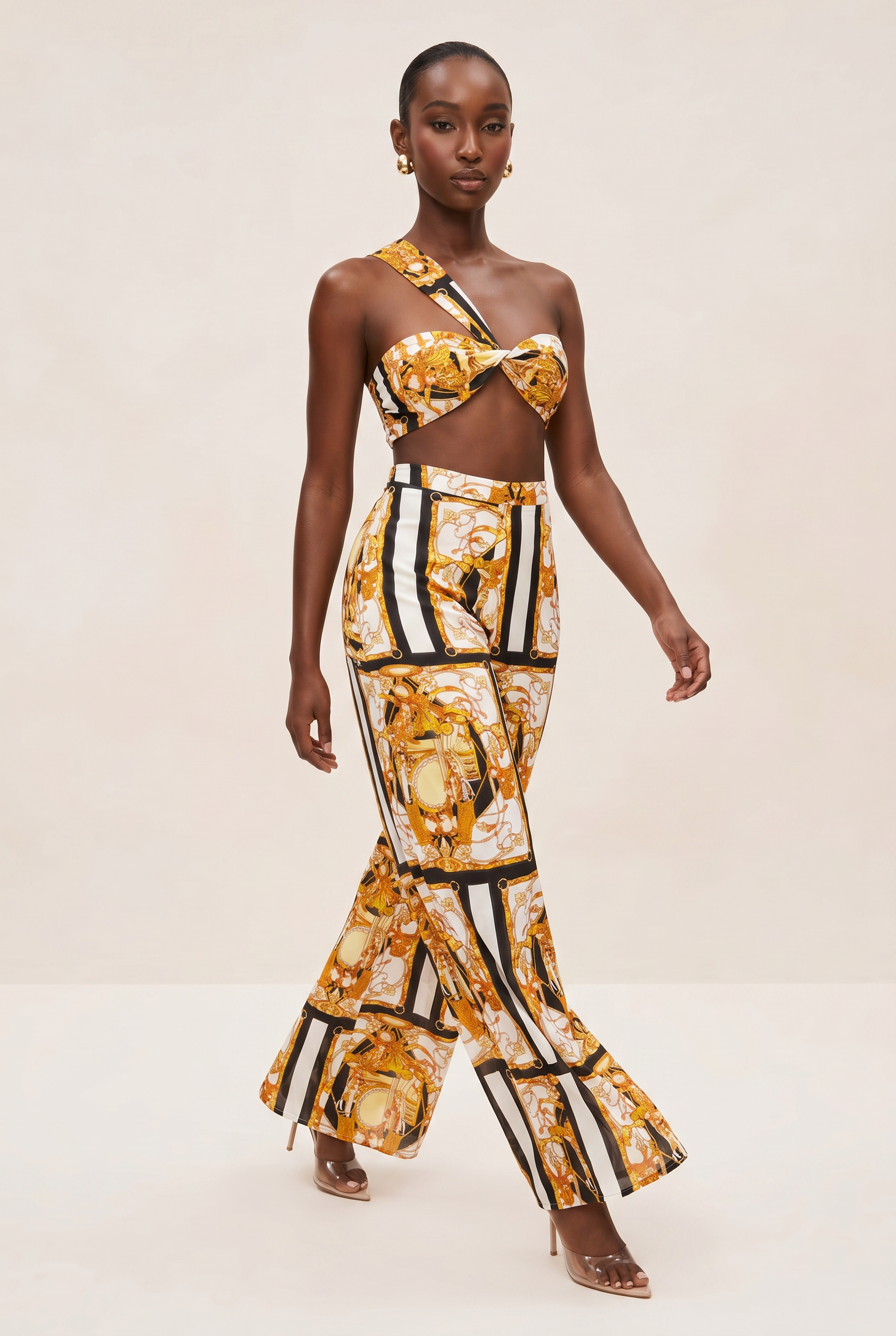 Model wearing a gold and black patterned outfit on a beige background