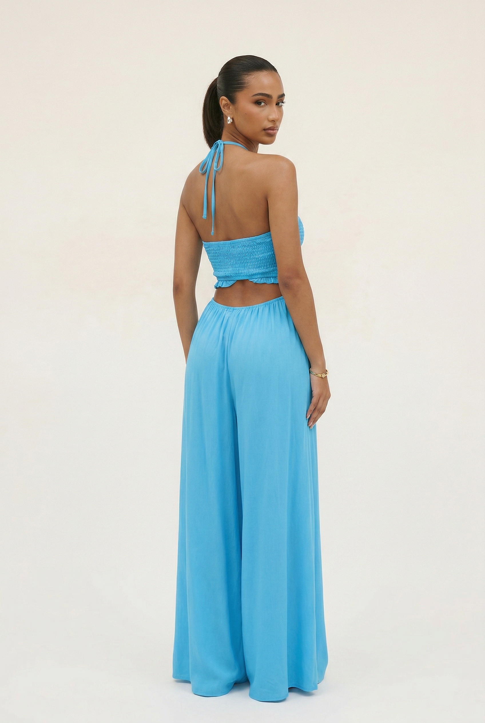 Woman wearing a blue two-piece outfit on a white background