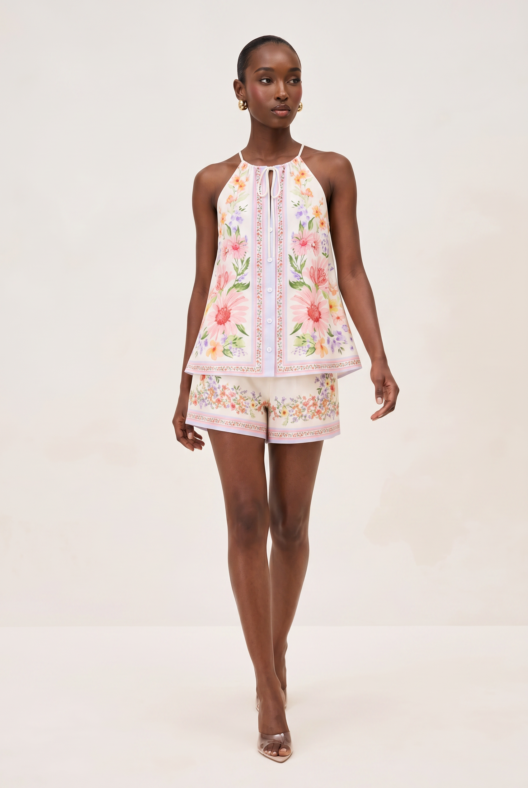 Woman wearing a floral dress and shorts on a white background