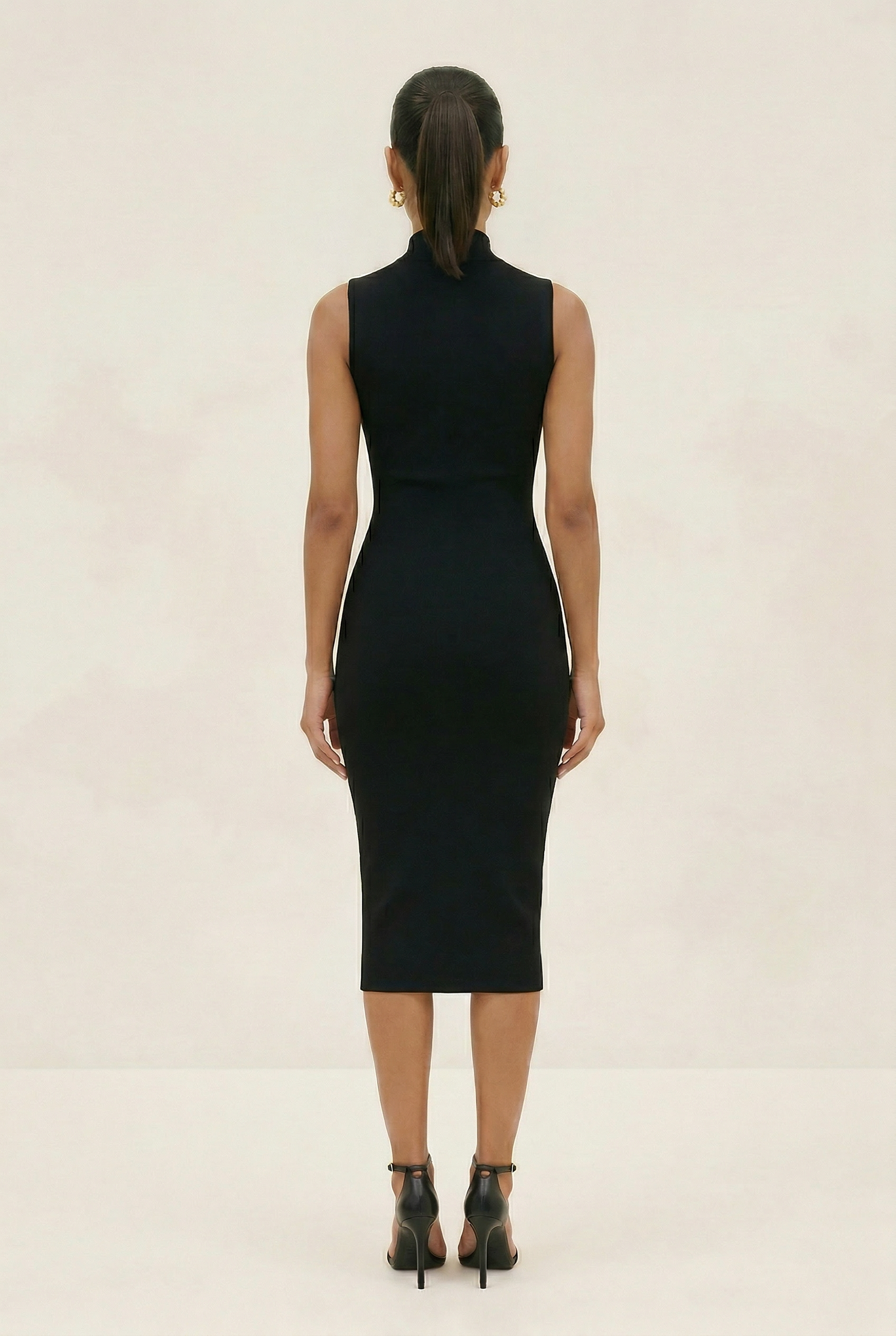 Woman wearing a black sleeveless dress on a beige background