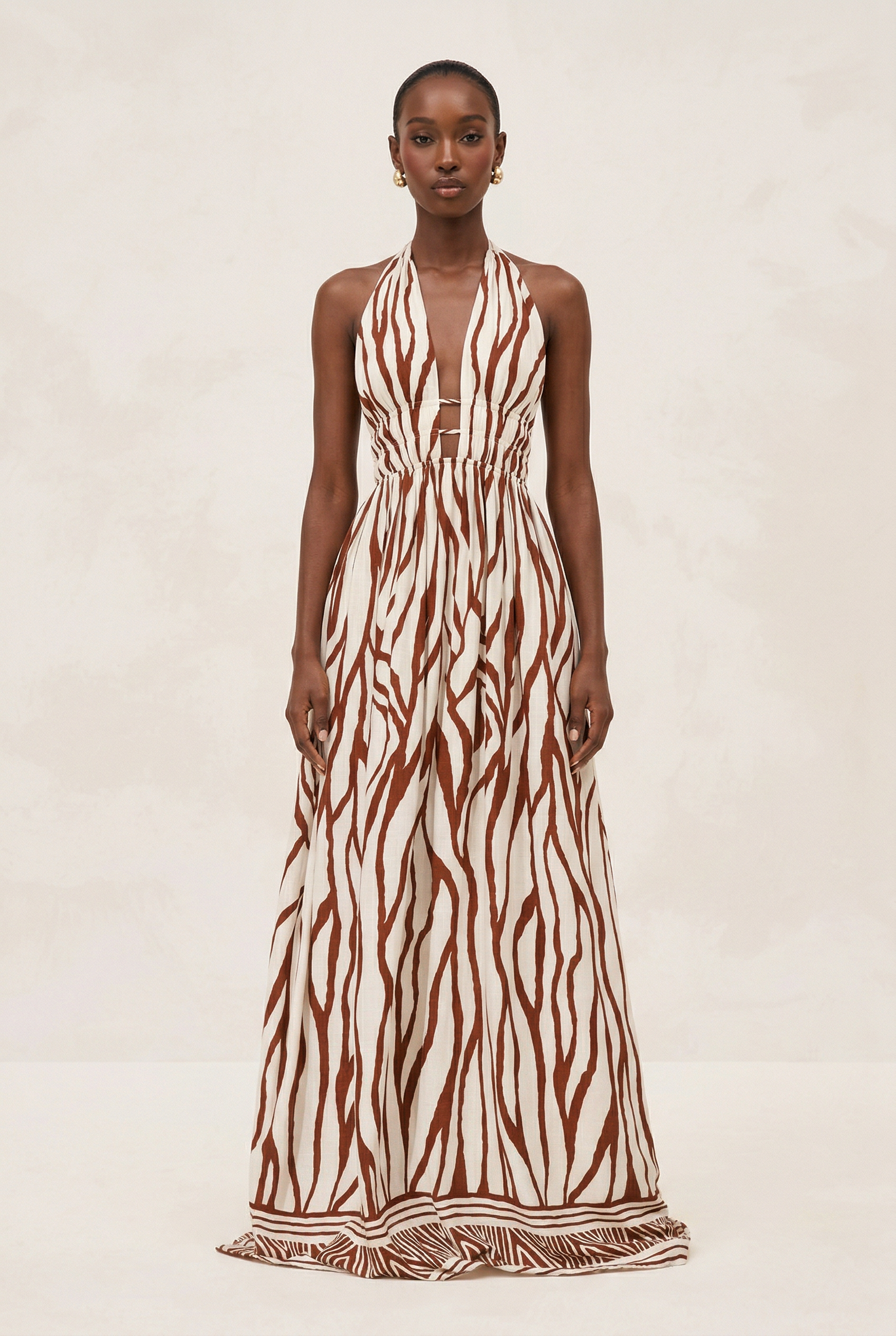 Woman wearing a long dress with a zebra pattern on a beige background
