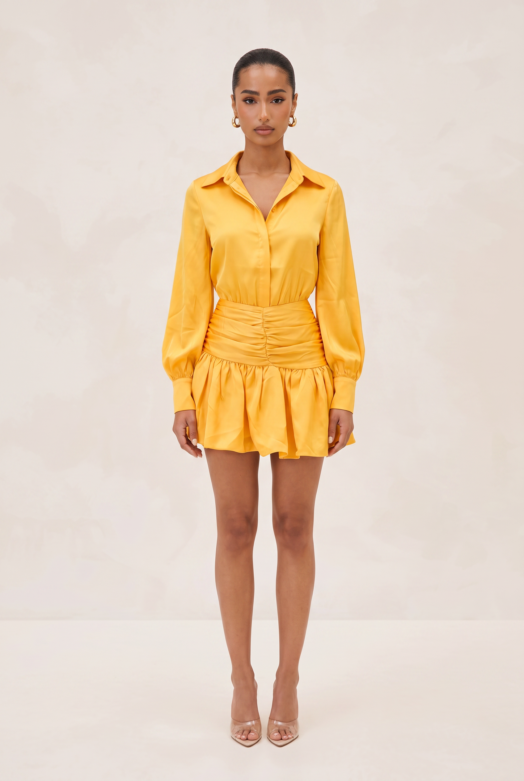 Woman wearing a yellow dress against a plain background